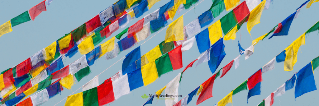  Brightly colored Tibetan prayer flags fluttering against a clear blue sky.